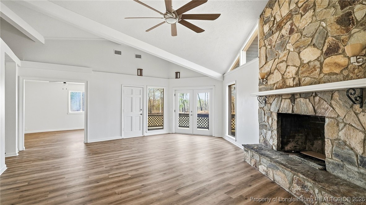 10765 Barker 10 Mile Road St. Pauls, NC 28384 - Photo 7 of 48 a view of an empty room with wooden floor fireplace and a window