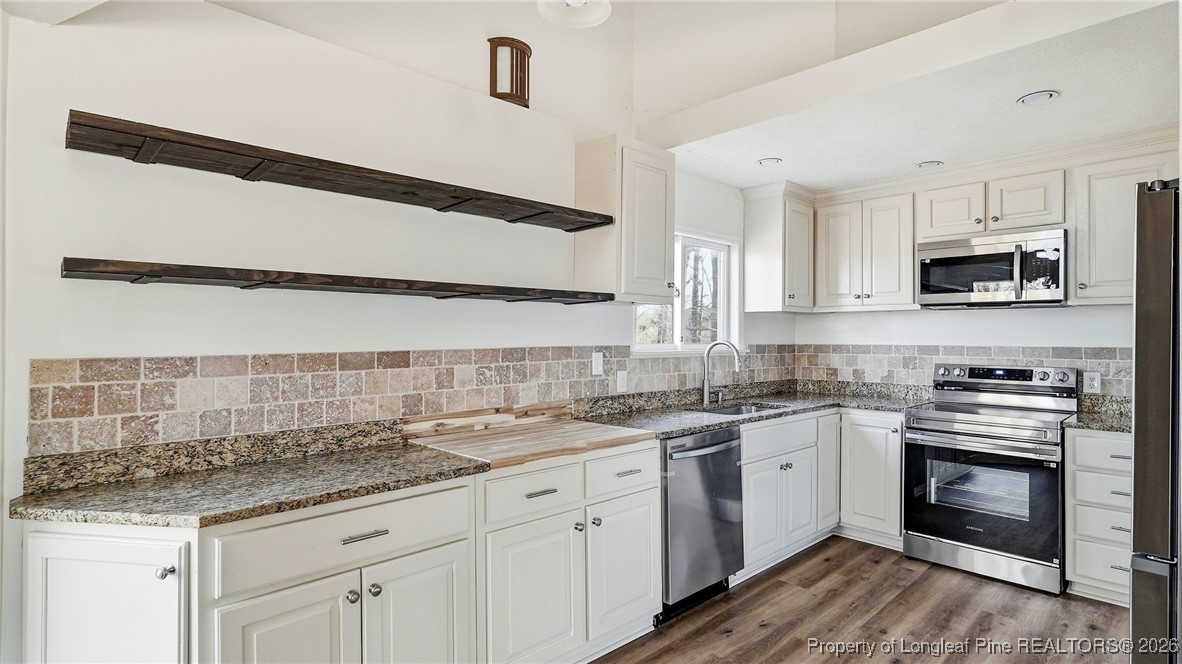 10765 Barker 10 Mile Road St. Pauls, NC 28384 - Photo 8 of 48 a kitchen with stainless steel appliances granite countertop a sink and stove top oven