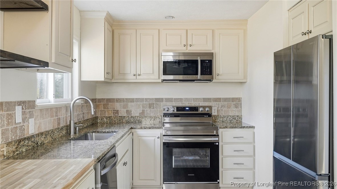 10765 Barker 10 Mile Road St. Pauls, NC 28384 - Photo 9 of 48 a kitchen with stainless steel appliances granite countertop a stove a sink and a refrigerator
