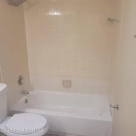 a bathroom with a toilet and a bath tub