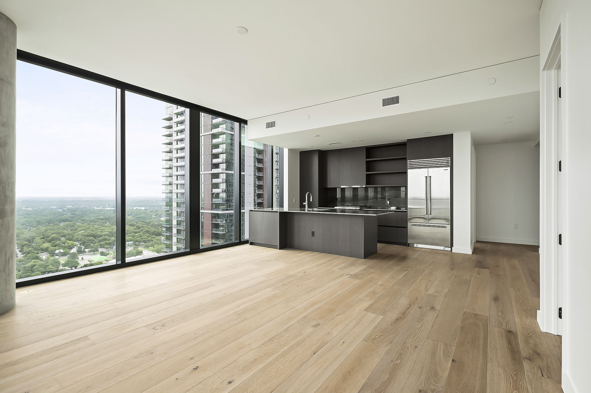 610 Davis Street, Unit 2812 Austin, TX 78701 - Photo 6 of 32 a large white room with kitchen view and wooden floor