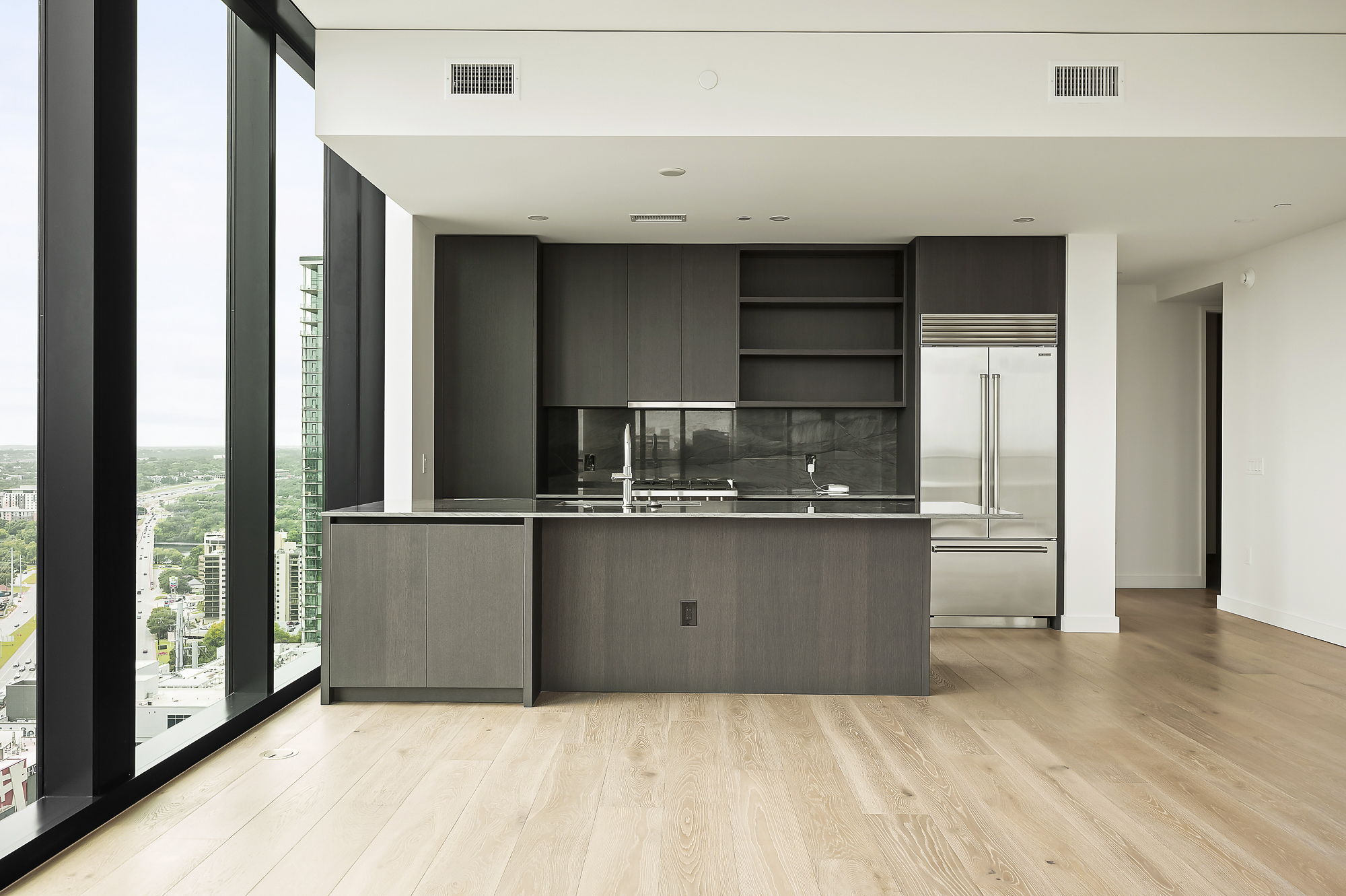 610 Davis Street, Unit 2812 Austin, TX 78701 - Photo 7 of 32 a kitchen with kitchen island granite countertop a refrigerator and a sink