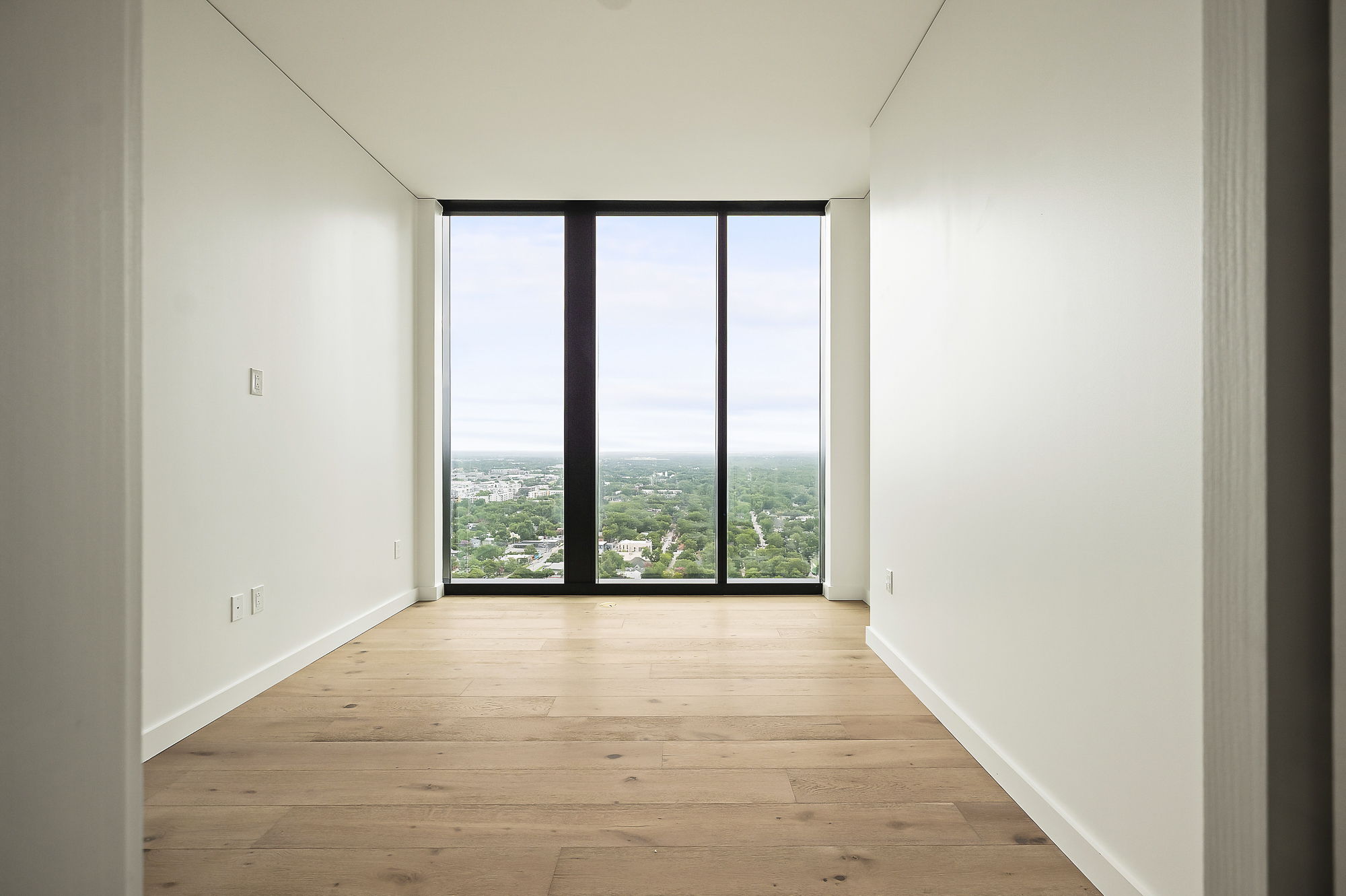 610 Davis Street, Unit 2812 Austin, TX 78701 - Photo 10 of 32 a view of an empty room with wooden floor and a window