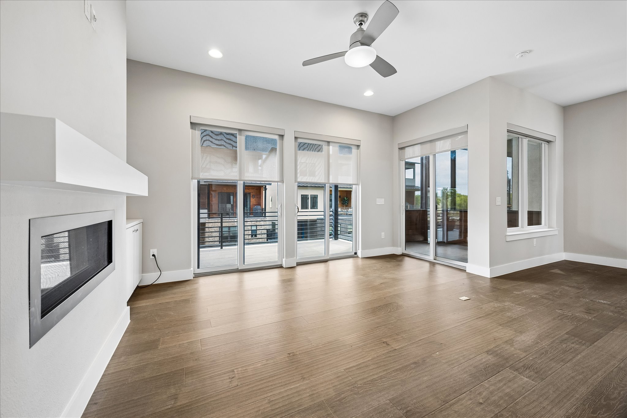 5006 Pecan Springs Road, Unit 6 Austin, TX 78723 - Photo 7 of 30 Hardwood floors and a sleek fireplace anchor this well-lit living space with ample balcony access.