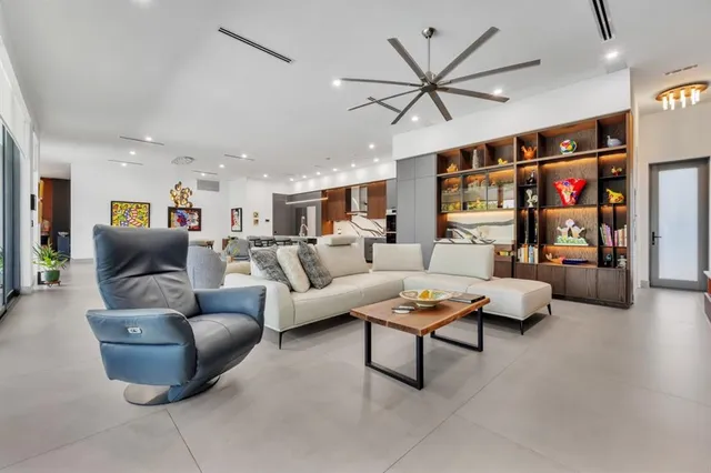 a kitchen with stainless steel appliances kitchen island granite countertop a refrigerator a stove a sink and a dining table with wooden cabinet