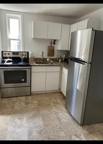 a kitchen with a refrigerator sink and cabinets