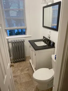 a bathroom with a granite countertop toilet sink and mirror