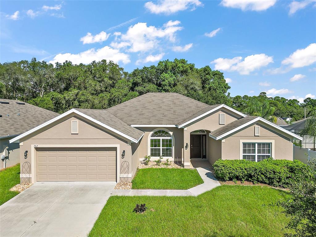 707 Bradley Way Fruitland Park, FL 34731 - Photo 1 of 34 a front view of a house with a yard and garage