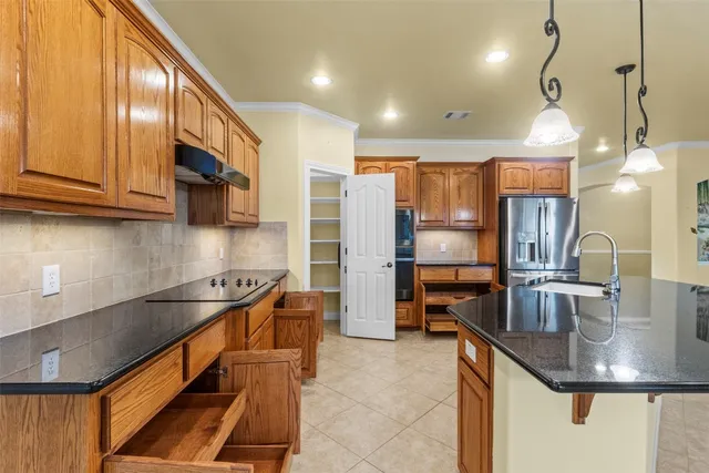 a kitchen with stainless steel appliances granite countertop a sink refrigerator and cabinets