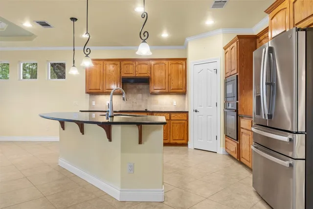 a kitchen with stainless steel appliances kitchen island a refrigerator and a sink