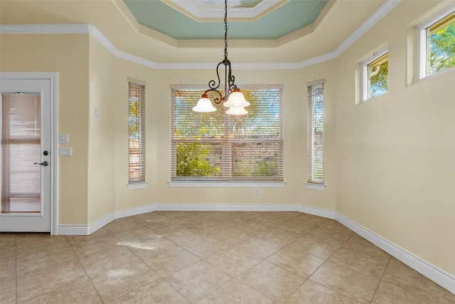 an empty room that has a window and a chandelier