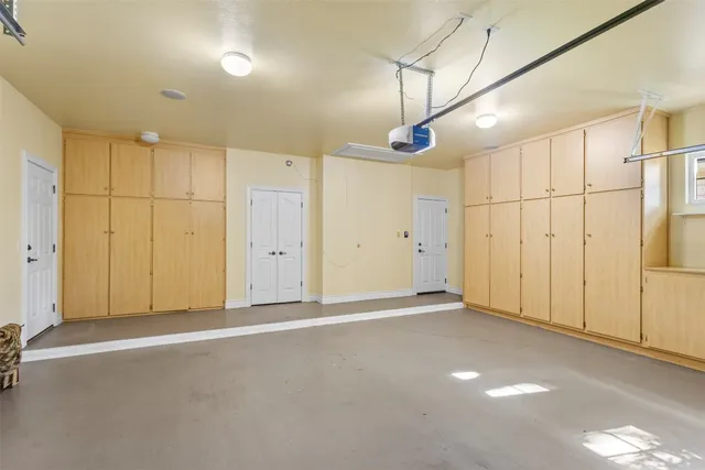 a backyard of a house with plants and large tree