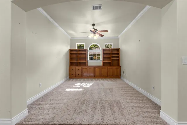 an empty room with windows and ceiling fan