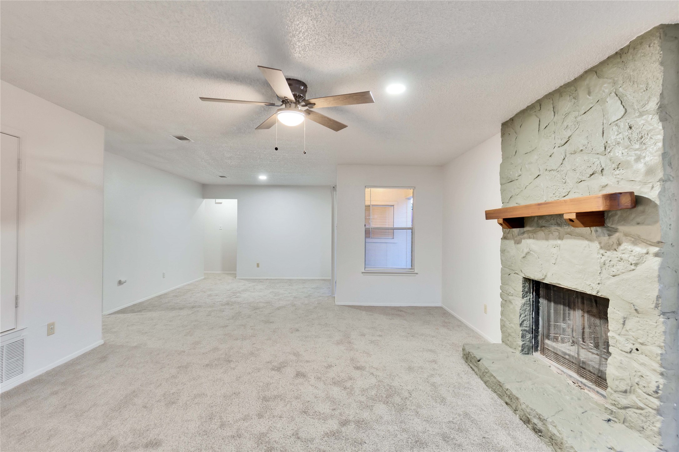 2807 Firecrest Drive Austin, TX 78748 - Photo 26 of 30 Spacious living area featuring a stone fireplace with a wood mantle, neutral carpeting, recessed lighting, and a ceiling fan