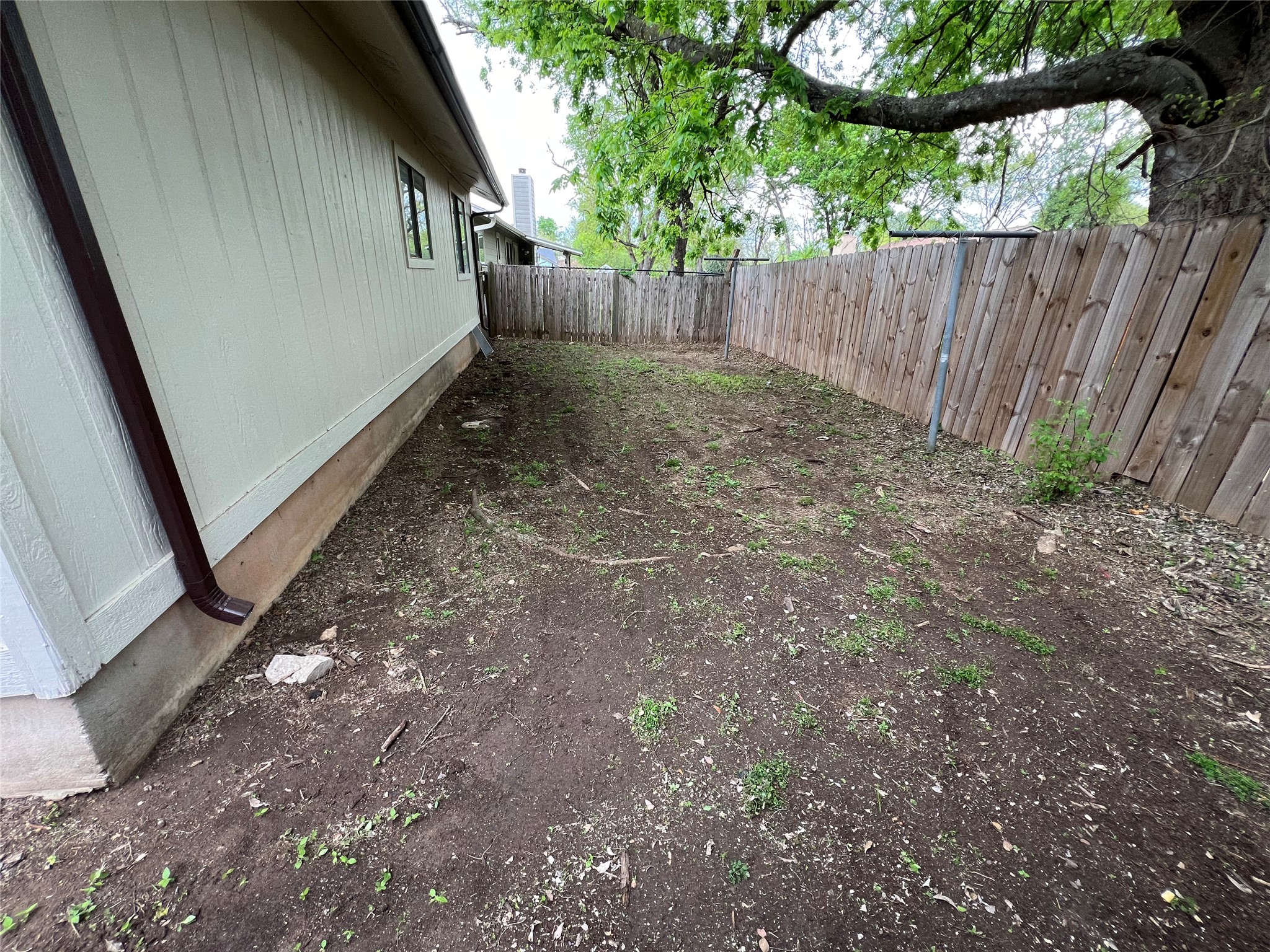2807 Firecrest Drive Austin, TX 78748 - Photo 27 of 30 Rear yard area featuring a wood privacy fence, perimeter landscaping, and mature trees