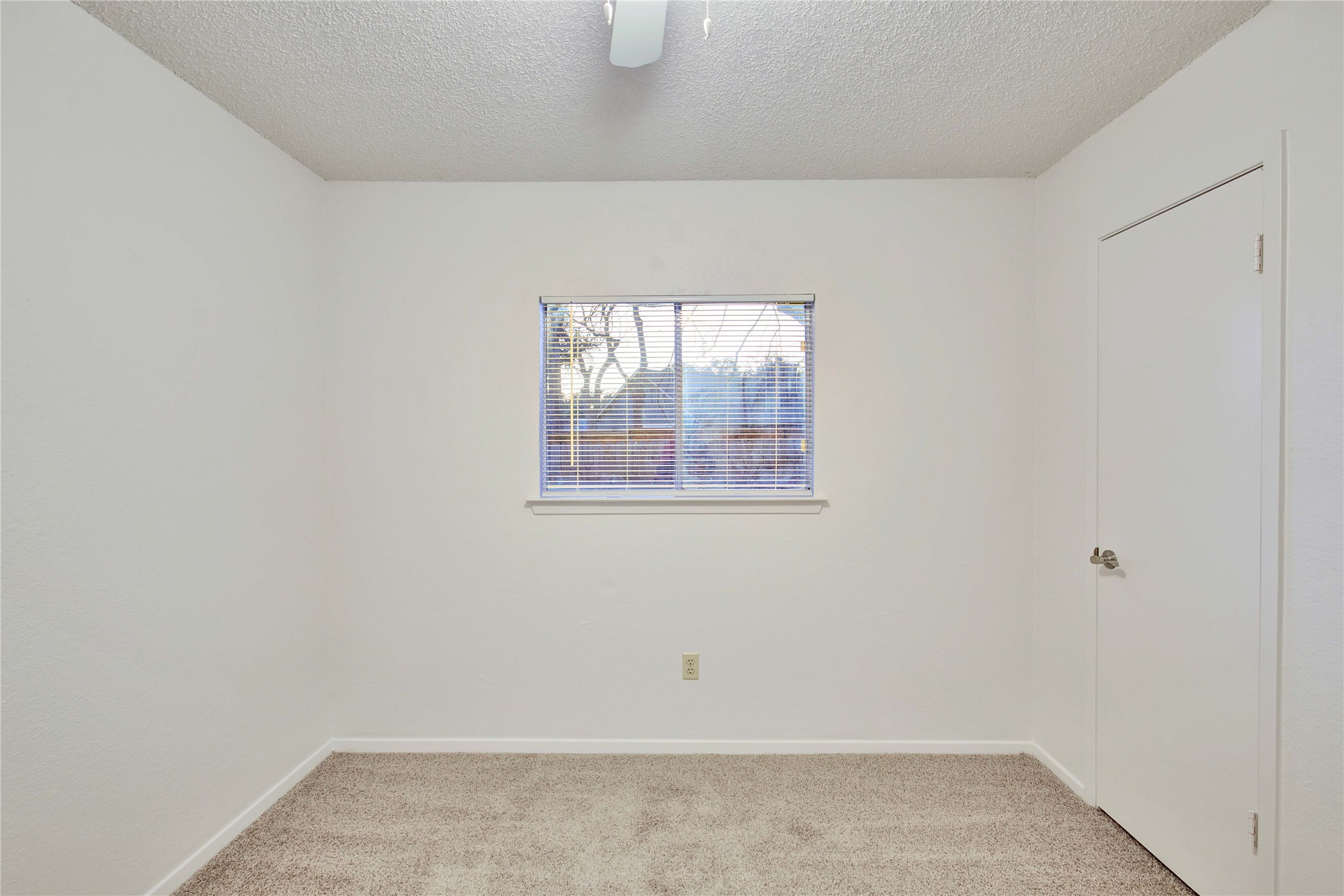 2807 Firecrest Drive Austin, TX 78748 - Photo 9 of 30 Neutral wall paint, window with horizontal blinds, overhead ceiling fan, white trim, and carpeted flooring