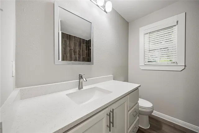 a bathroom with a granite countertop toilet and a bathtub