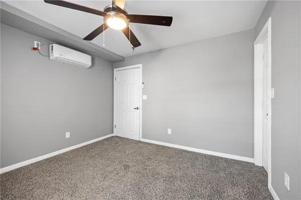 an empty room with chandelier fan