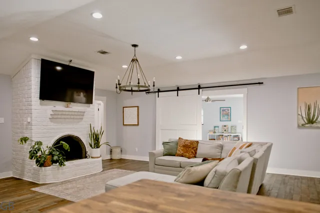 a living room with furniture a fireplace and a flat screen tv