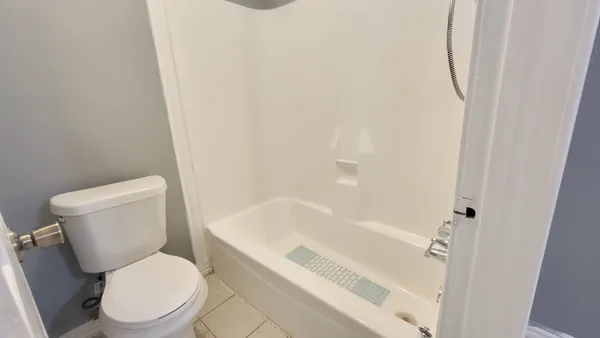 a white toilet sitting next to a bath tub