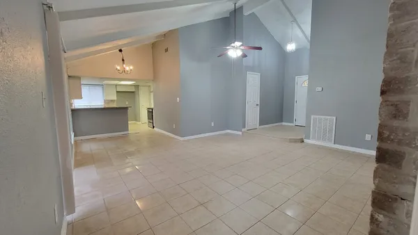 a view of a hallway with chandelier and a bathroom