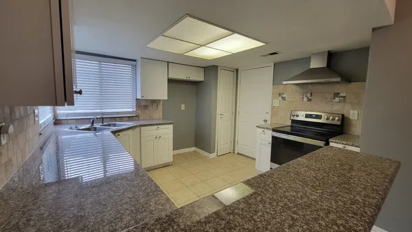 a kitchen with a sink a stove and cabinets