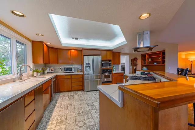 a kitchen with stainless steel appliances granite countertop sink stove and refrigerator