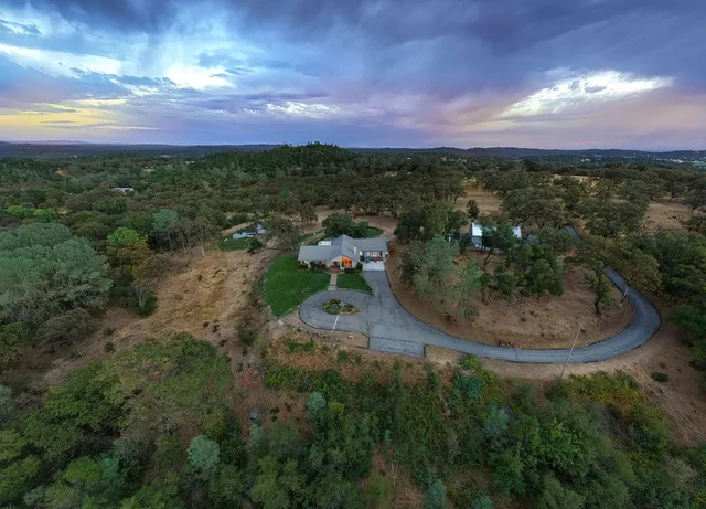 an aerial view of a house with a yard