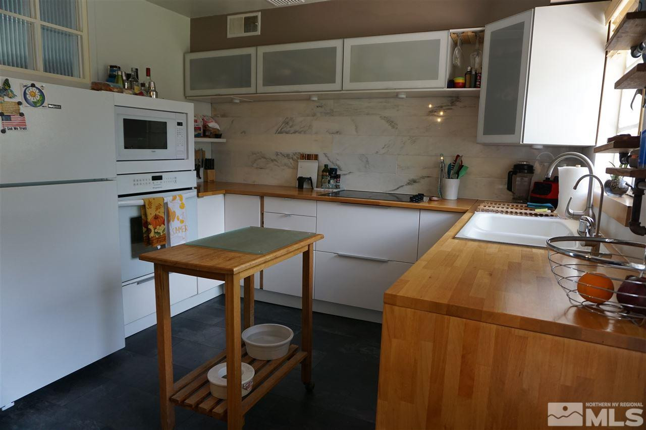 845 Bates Avenue Reno, NV 89502 - Photo 11 of 18 a kitchen with a table chairs and a refrigerator