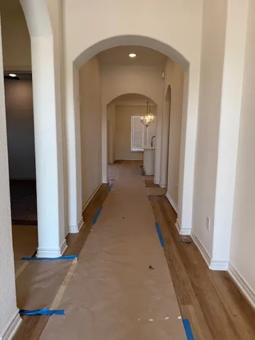 a view of a hallway with wooden floor and a living room