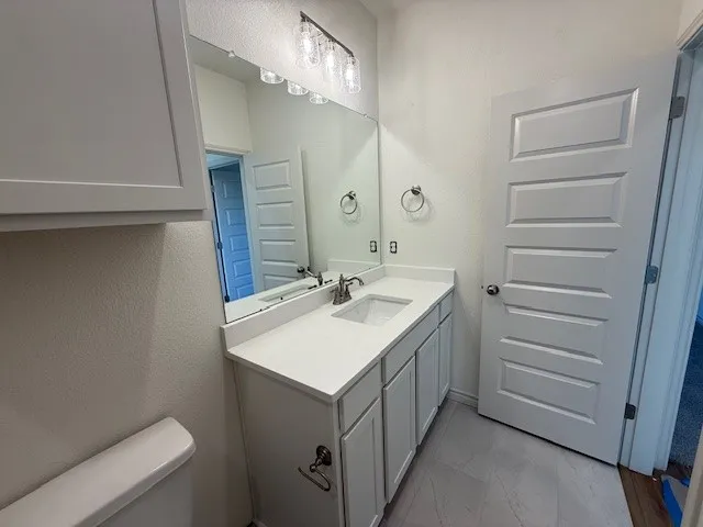 a bathroom with a sink a toilet and a mirror