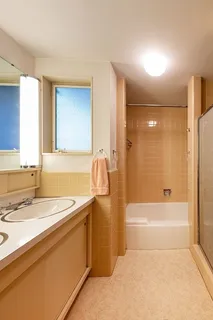 a bathroom with a granite countertop sink a toilet and shower