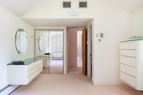 a living room with furniture a bed and a mirror