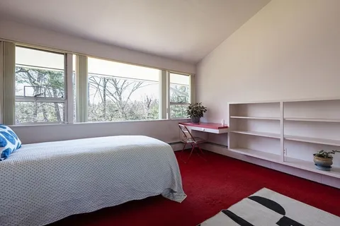a bedroom with a bed and a large window