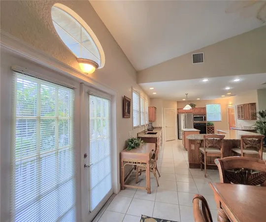 a large kitchen with kitchen island a large counter top stainless steel appliances and cabinets