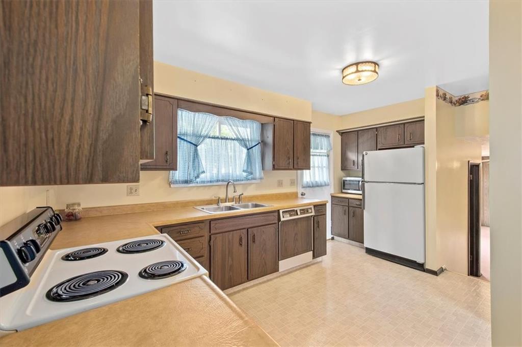 756 Charles Street Rochester, PA 15074 - Photo 8 of 25 a kitchen with a sink a refrigerator and a stove