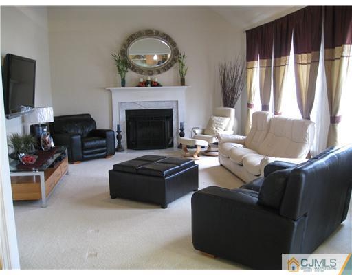 105 Autumn Road Old Bridge, NJ 07747 - Photo 3 of 16 a living room with furniture a flat screen tv and a fireplace