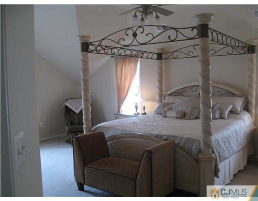 105 Autumn Road Old Bridge, NJ 07747 - Photo 8 of 16 a bedroom with a bed a chandelier and dresser