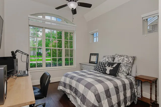 a bedroom with a bed television and a large window