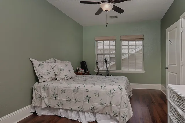 a large bed sitting in a bedroom next to a window and a chandelier