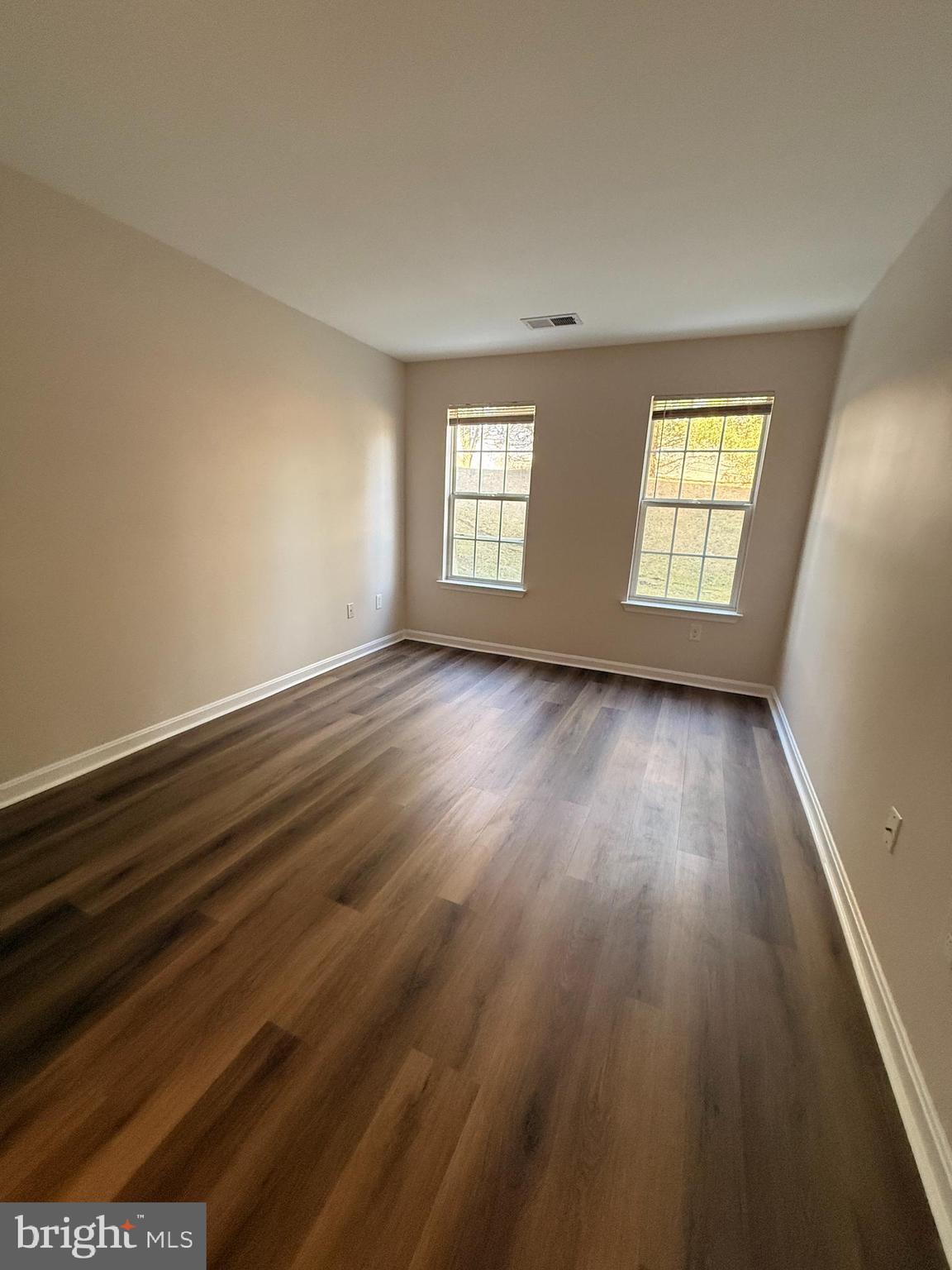 8801 Stoneridge Circle, Unit T2 Baltimore, MD 21208 - Photo 16 of 24 an empty room with wooden floor and windows