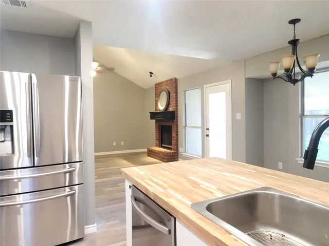 a kitchen with kitchen island a counter top space wooden floor and stainless steel appliances