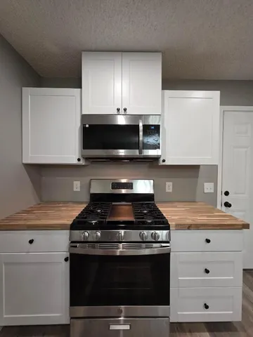 a kitchen with stainless steel appliances granite countertop a stove and a microwave