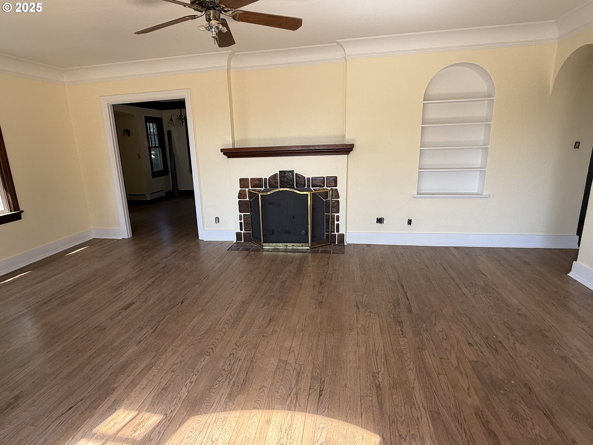311 Northwest 11th Street Pendleton, OR 97801 - Photo 4 of 11 a view of a livingroom with a fireplace a ceiling fan and wooden floor
