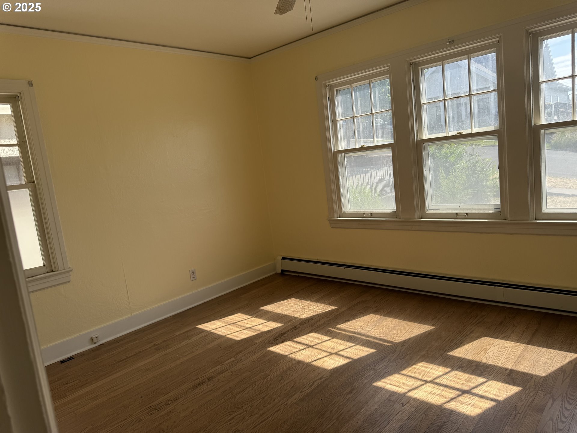 311 Northwest 11th Street Pendleton, OR 97801 - Photo 7 of 11 an empty room with wooden floor and windows