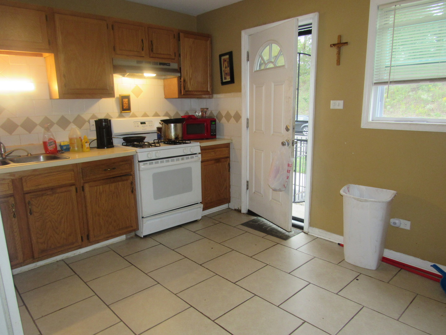 1132 East 81st Street, Unit H Chicago, IL 60619 - Photo 5 of 19 a kitchen with a sink a refrigerator and cabinets