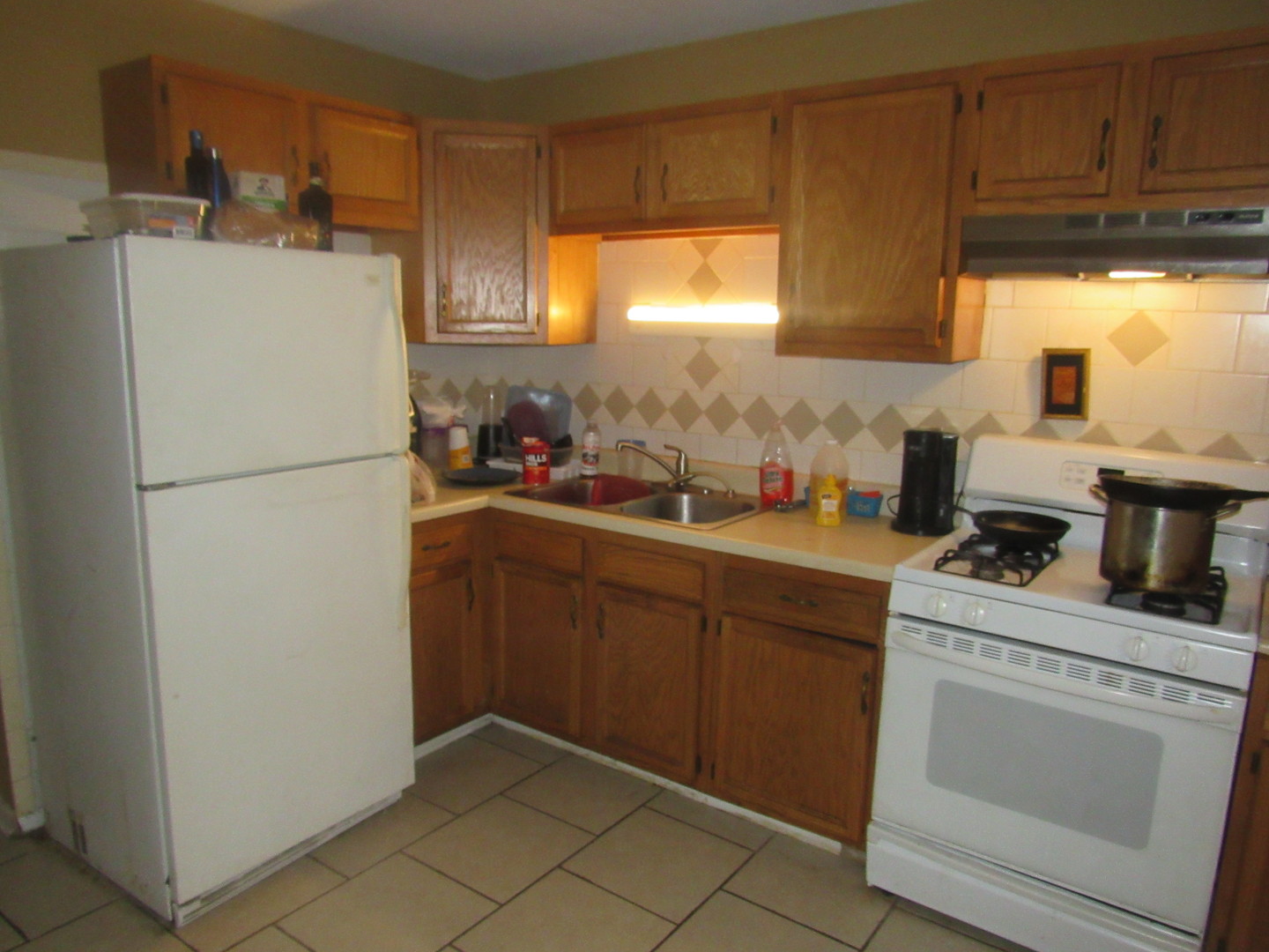 1132 East 81st Street, Unit H Chicago, IL 60619 - Photo 6 of 19 a kitchen with a refrigerator sink and cabinets