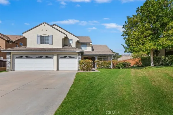 a view of a big house with a big yard and large trees