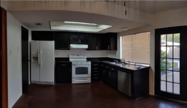 a kitchen with stainless steel appliances granite countertop a refrigerator a sink and a stove