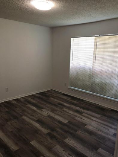 6432 Bankside Drive Houston, TX 77096 - Photo 10 of 14 a view of empty room with wooden floor and fan